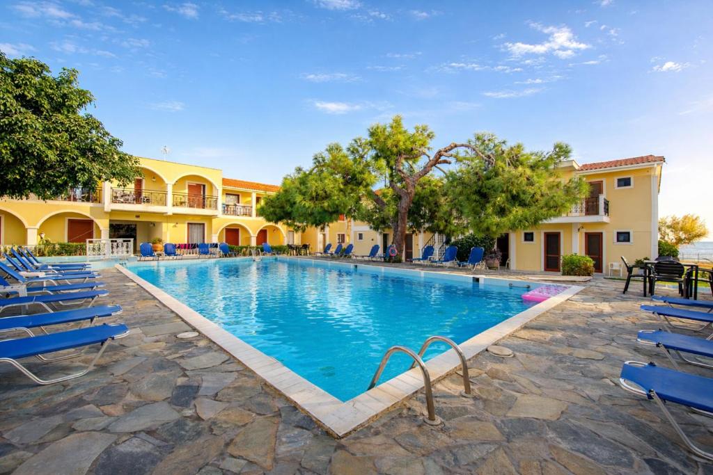 a swimming pool with blue chairs and a resort at Iliessa Beach Hotel by GHH in Argassi