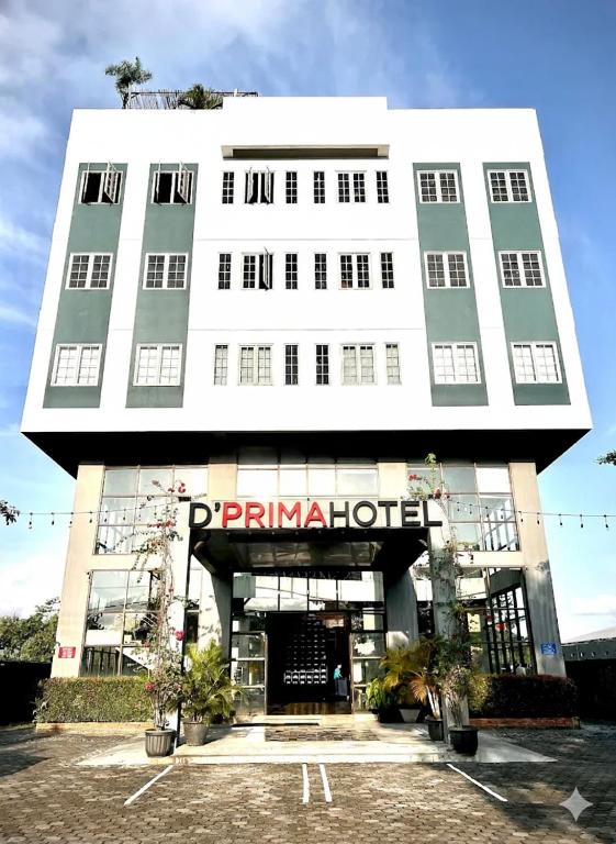 a large white building with a puma hotel at d'primahotel Yogyakarta in Yogyakarta