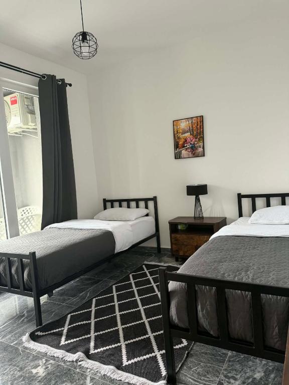 a bedroom with two beds and a table with a lamp at TriM Apartments in Travnik