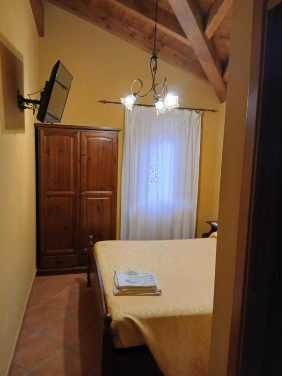 a bedroom with a bed and a window with a white curtain at Borgo degli Ulivi in Morcone