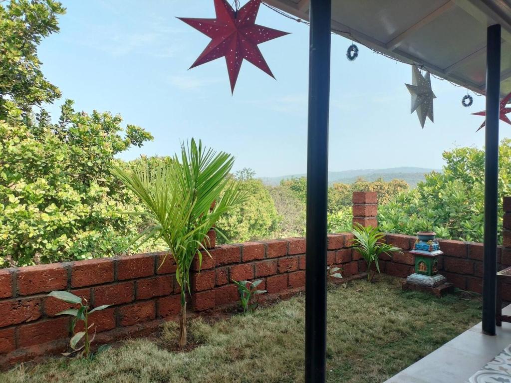 a view from the patio of a house with a brick wall at Devrai Villa in Dapoli