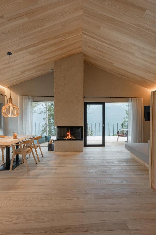 ein Wohnzimmer mit Kamin und einem Tisch in der Unterkunft Chalet Herol in Lüsen