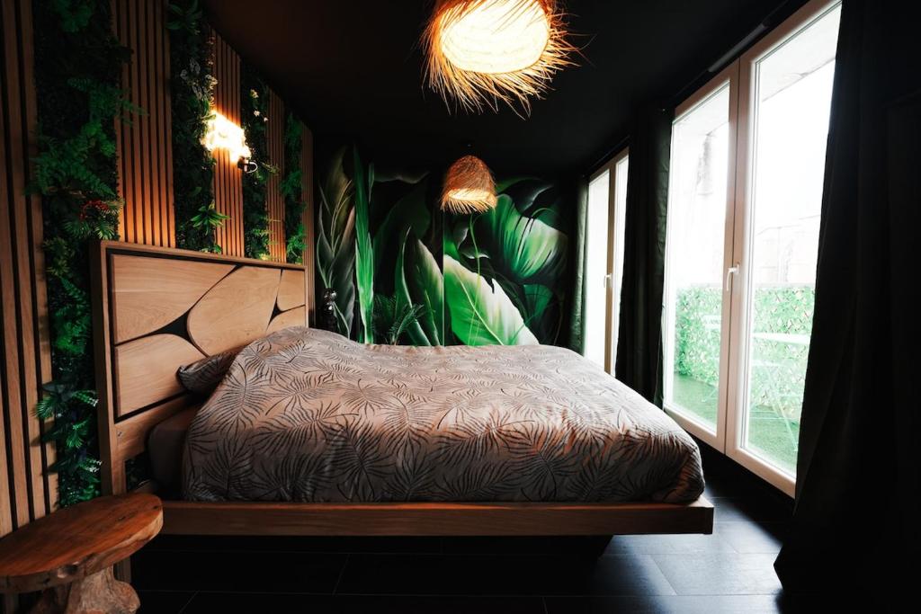 a bedroom with a bed in a room with windows at Jungle Room Dunkerque centre in Dunkerque