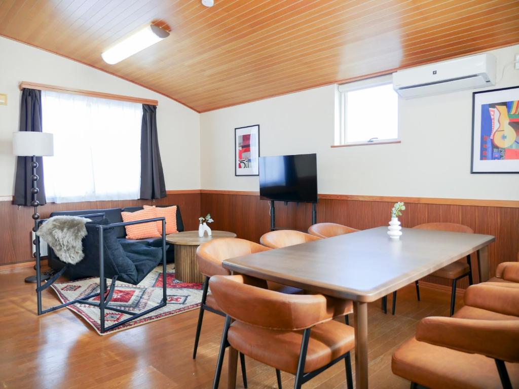 a room with a table and chairs and a television at 9Stay函館 in Hakodate