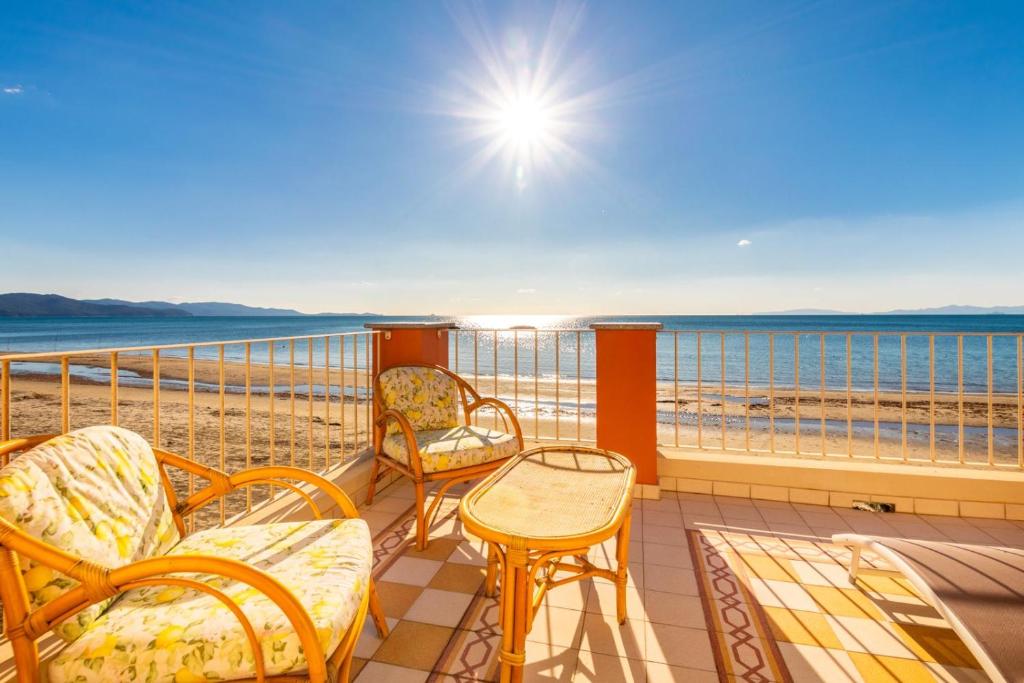 a balcony with chairs and a table on the beach at Villino Gelli in Follonica