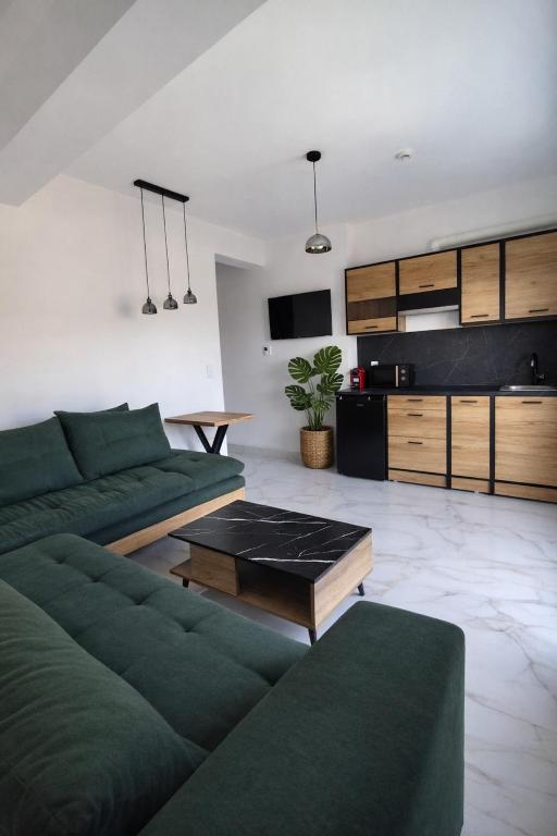 a living room with a green couch and a table at White Rocks Meteora in Kalabaka