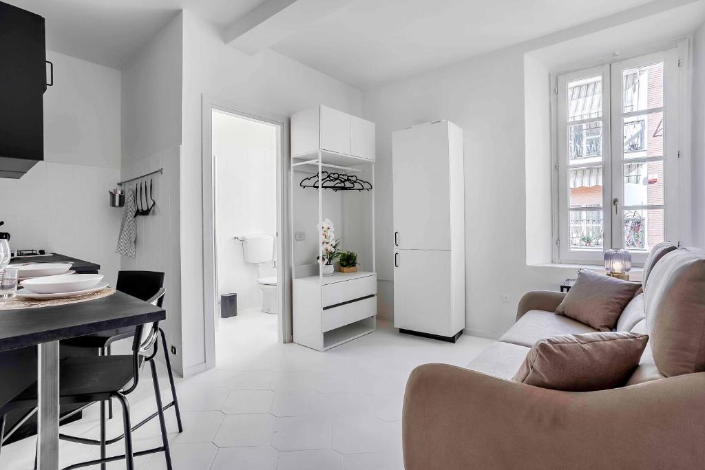 a white living room with a couch and a table at Borgo Riccio - Nice place in Parma in Parma