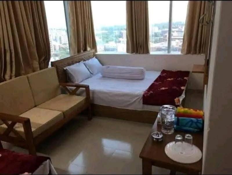 a room with a bed and a couch and a window at Hotel Sikder-02 Residential in Dhaka