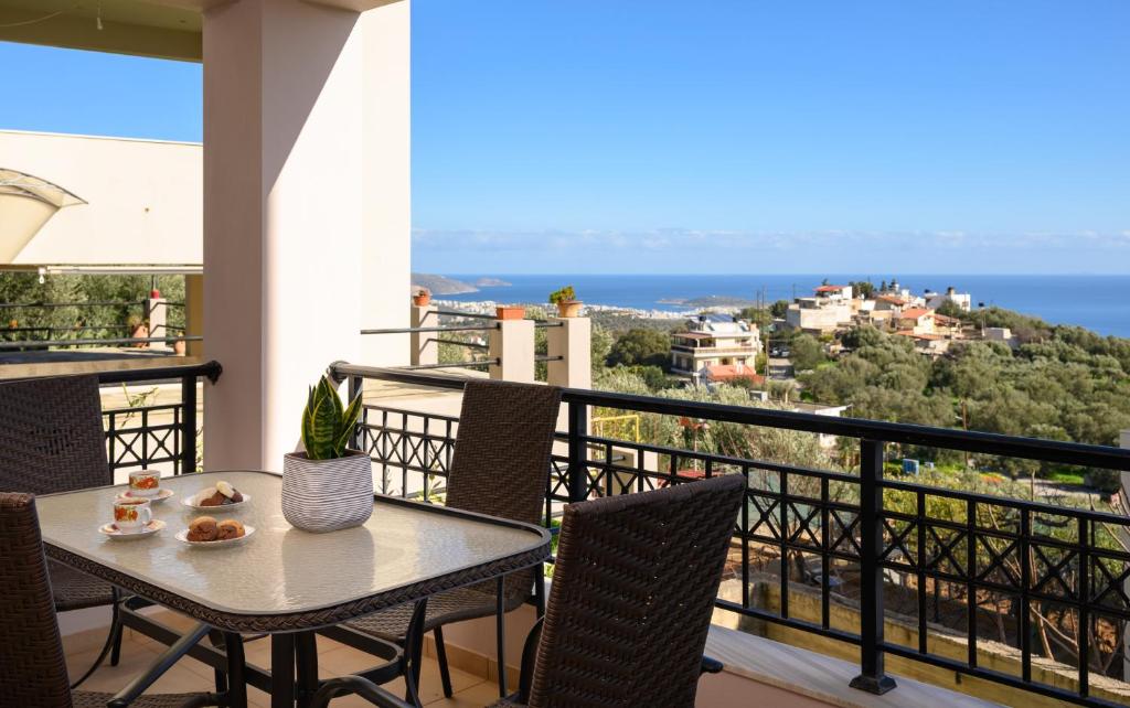 a table and chairs on a balcony with a view of the ocean at Gi & Vi House in Agios Nikolaos