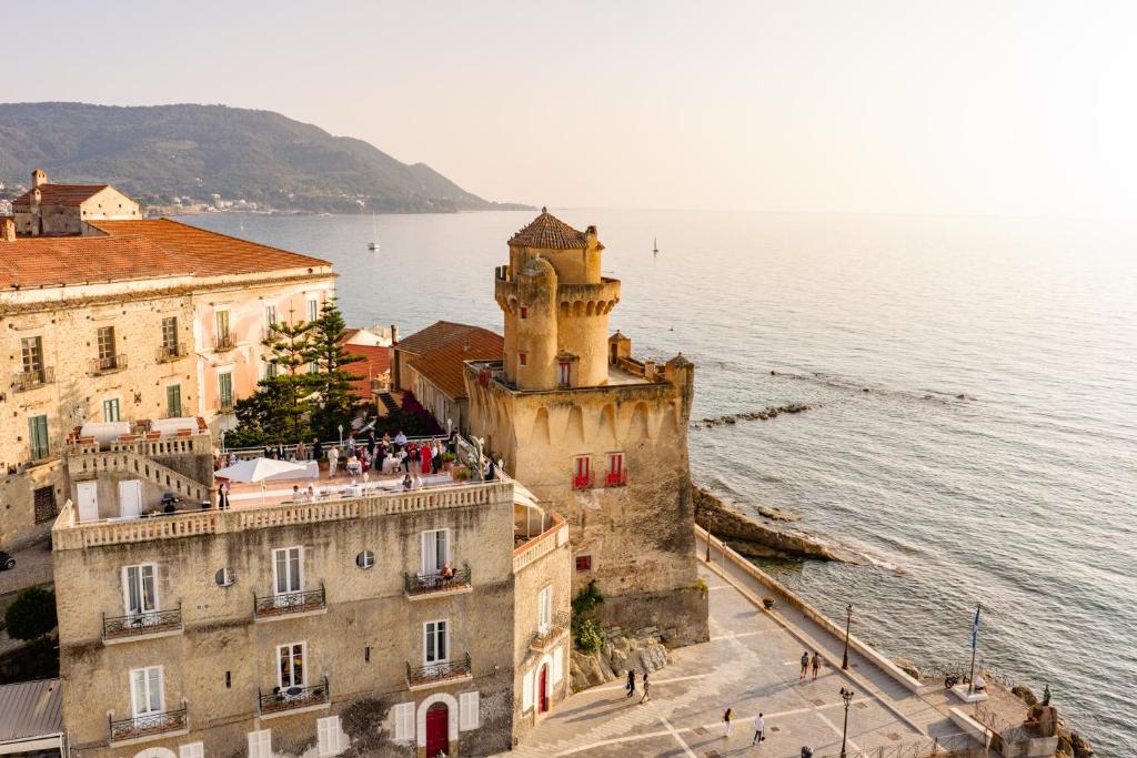 an old building next to a body of water at Torre Perrotti - Le suite in Santa Maria di Castellabate
