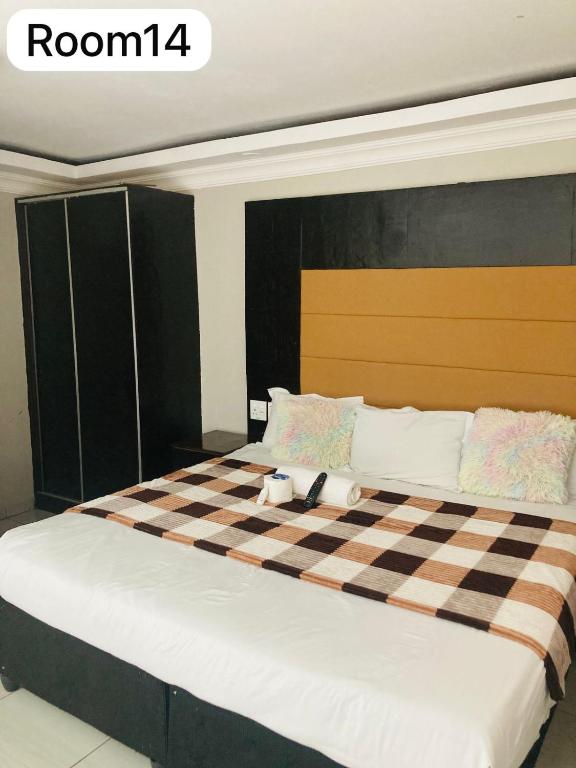 a bedroom with a bed with a checkered blanket at The Bright Guest House in Pretoria