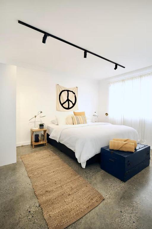 a bedroom with a large bed and a large window at Cronulla beach apartments in Cronulla