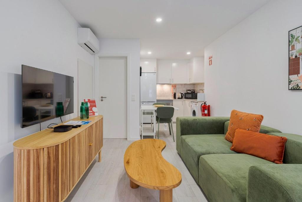 a living room with a green couch and a table at Moradia Bar Sela, By Home Match in Setúbal