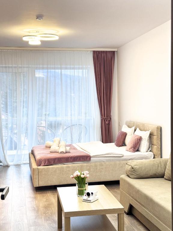 a living room with two beds and a couch at AVA Studio Sinaia in Sinaia