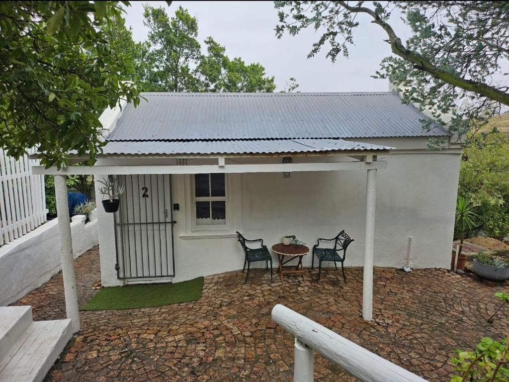 a small white house with two chairs and a table at Escape Root in Caledon