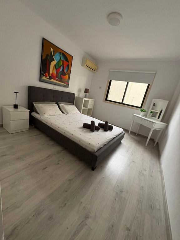 a bedroom with a large bed and a wooden floor at Theodoros Apt.79 in Paralimni