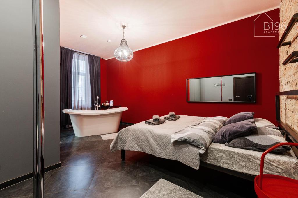 ein rotes Schlafzimmer mit Bett und Waschbecken in der Unterkunft ApartHotel Riga in Riga