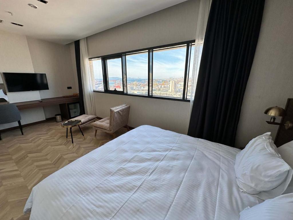 a hotel room with a bed and a large window at Plaza Residence in Tuzla