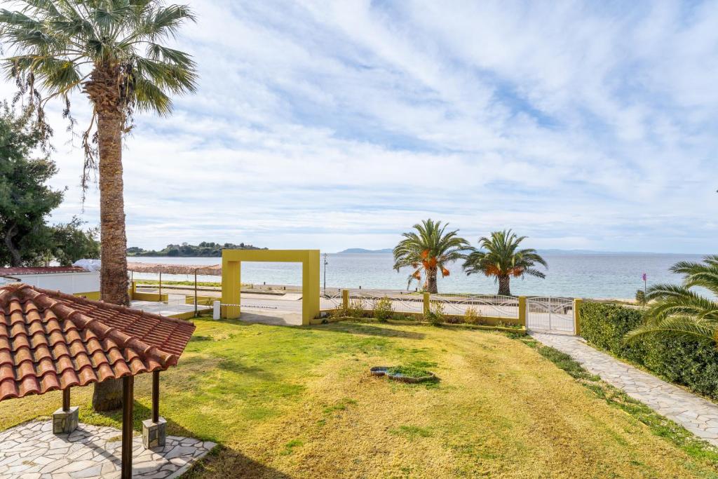 a park with palm trees and a view of the ocean at Chrissi Ammoudia in Toroni