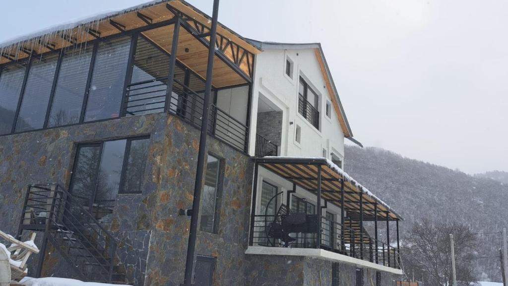 a large building with windows and a mountain at Guesthouse Laurbili in Mestia