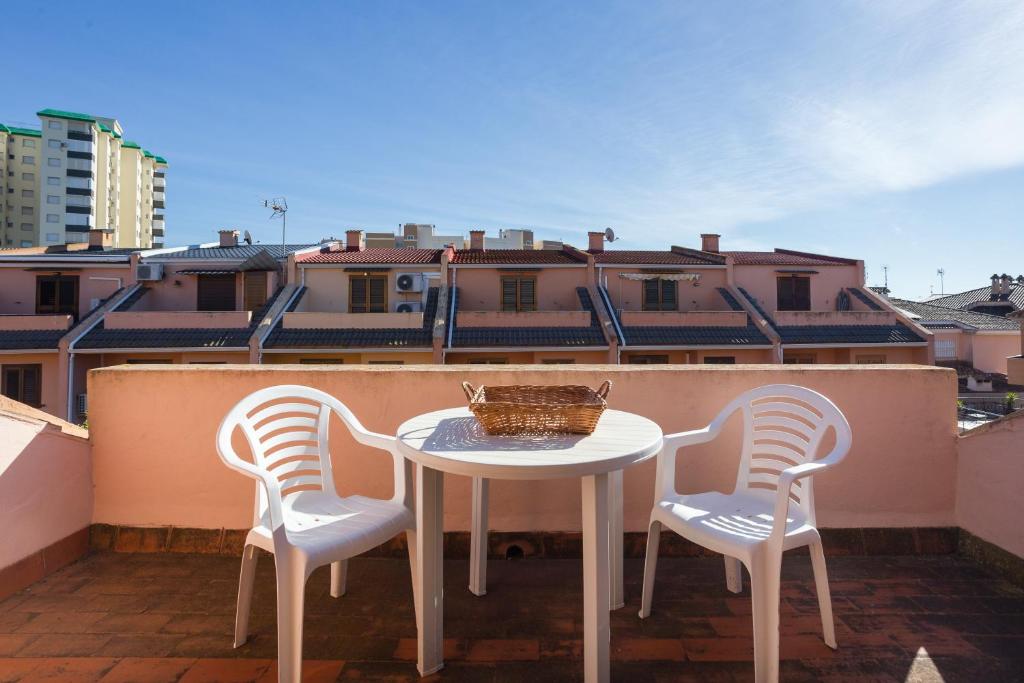 a table and two chairs on a balcony with a basket at Adosado Mareny Blau in Mareny Blau