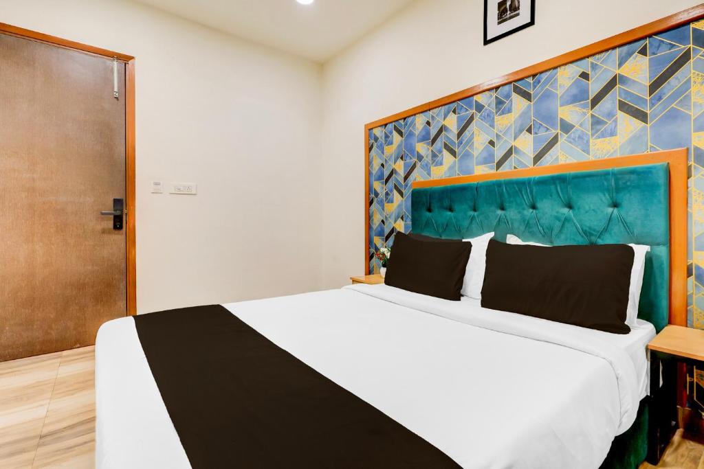 a bedroom with a large bed with a blue headboard at Super Townhouse Hotel Silver Saffron in New Delhi