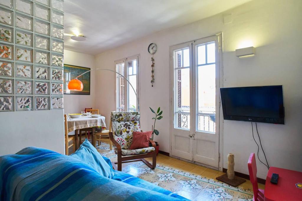 a living room with a blue couch and a tv at My Home in Barcelona in Barcelona