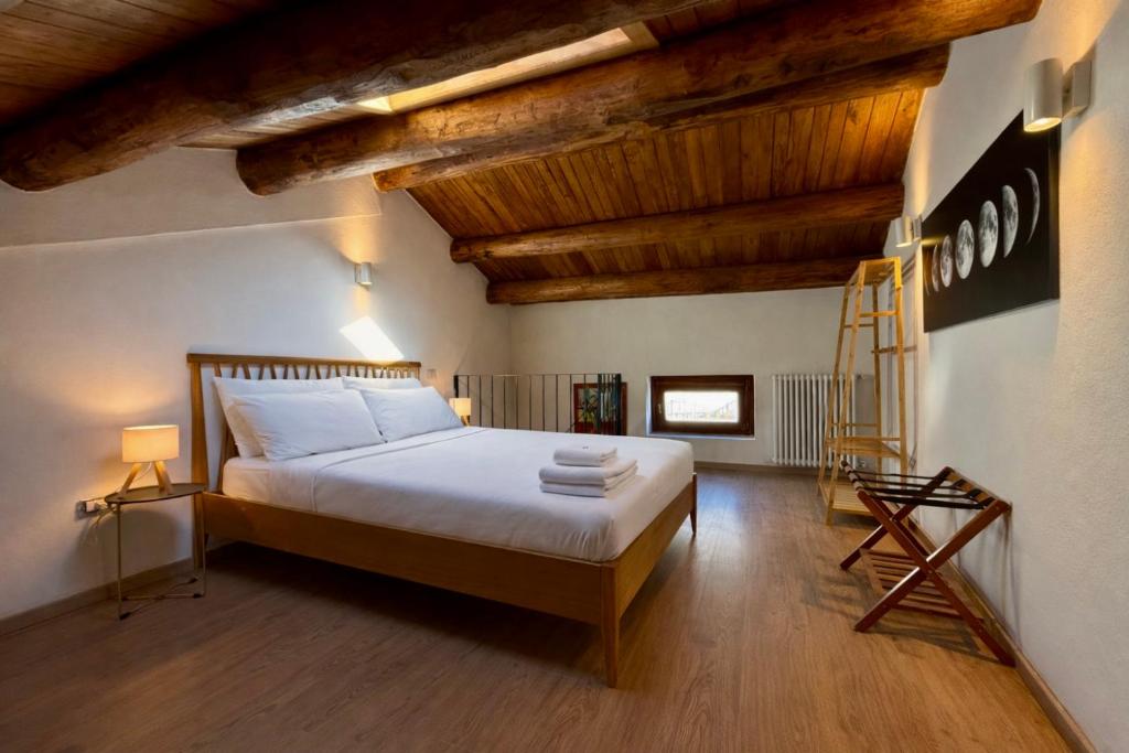 a bedroom with a large bed with wooden ceilings at Lilla Stuga in Montenero Val Cocchiara