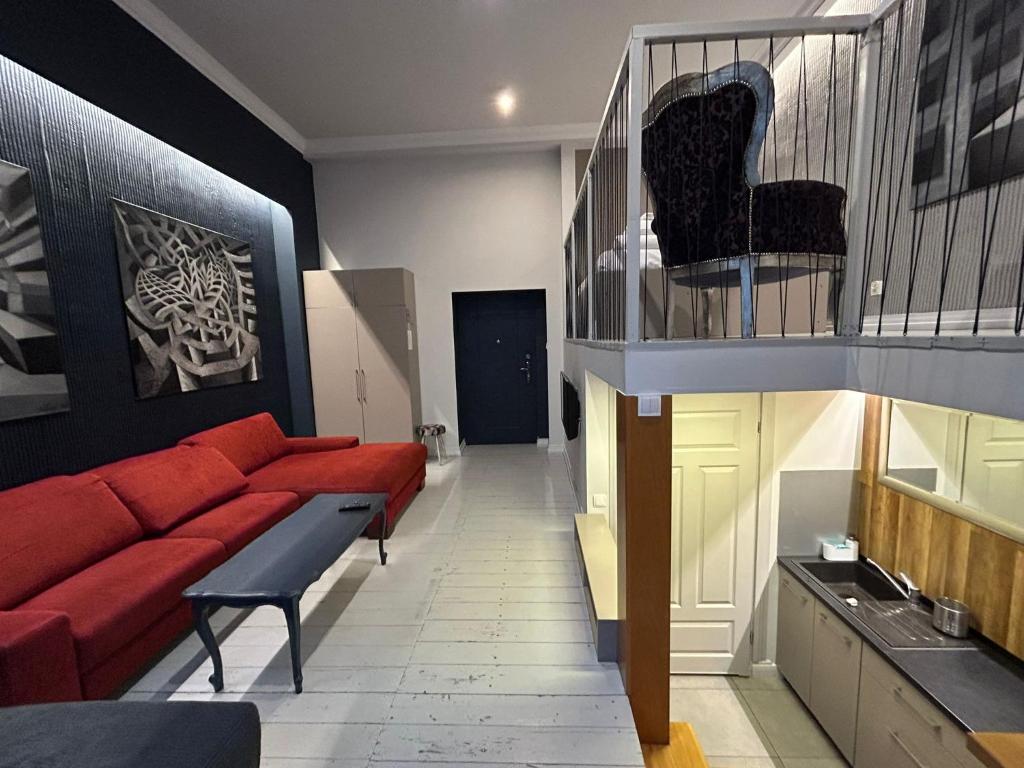 a living room with a red couch and a staircase at MoHo M in Wrocław