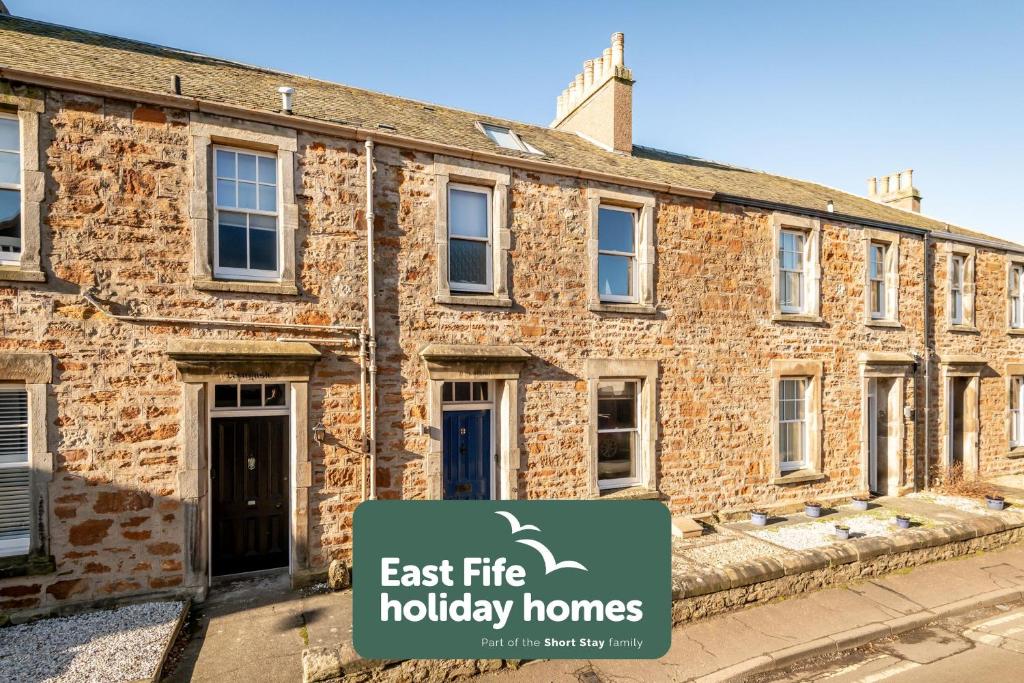 an old brick building with a sign in front of it at Dylsford - Elie in Elie