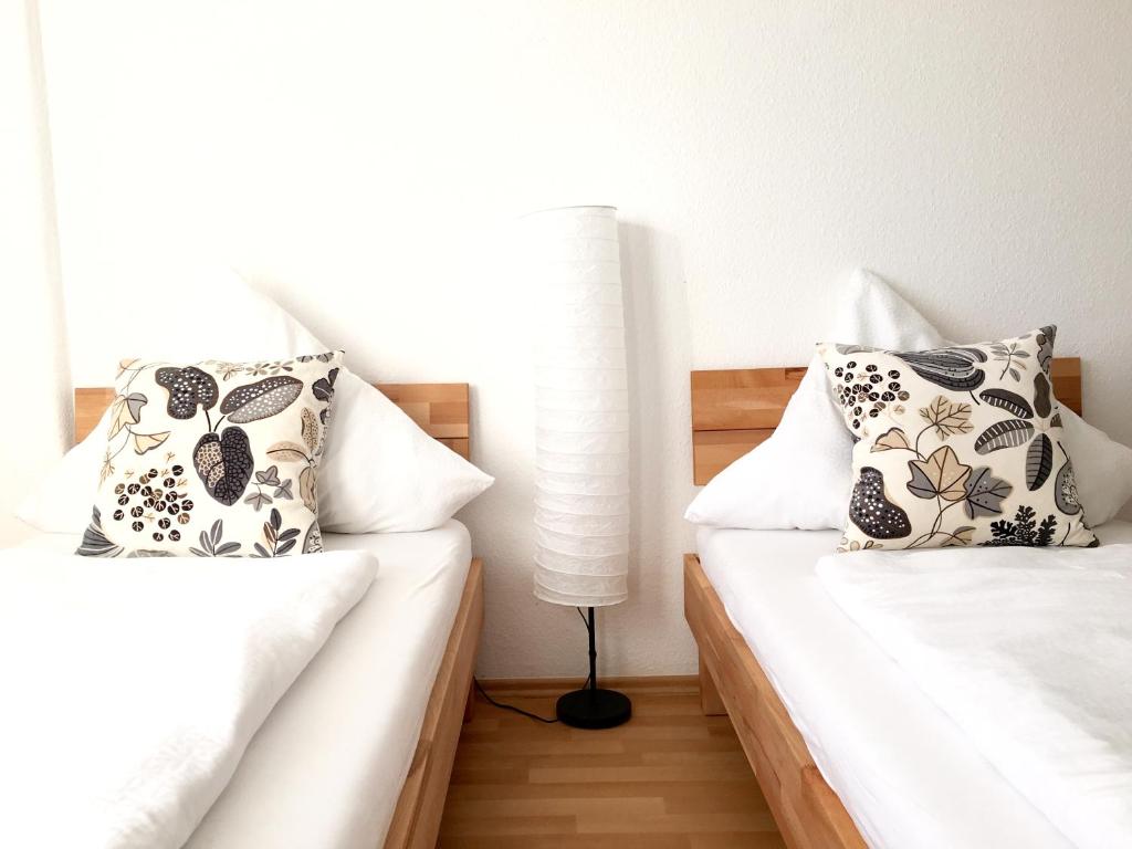 een slaapkamer met 2 bedden en een lamp bij Apartment Living Leipzig in Großzössen