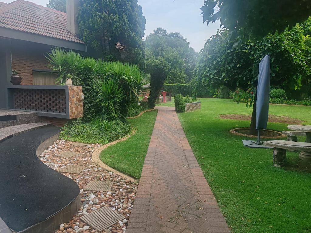 a garden with a bench and a walkway at Kahunaz in Vereeniging