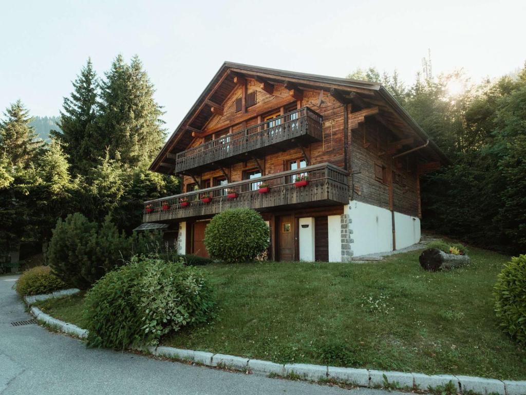 a large wooden house with a balcony on a yard at Chalet 4★, 11 pers, 6 ch, terrasse sud, animaux admis - FR-1-304-21 in La Clusaz