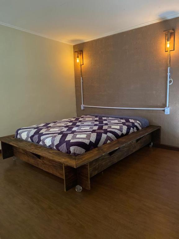 a bed in the corner of a room at Chalé Mi casa Su casa in Itamonte