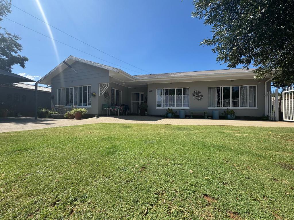 a house with a lawn in front of it at House Fynbos, 4 Bedroom house in Bloemfontein