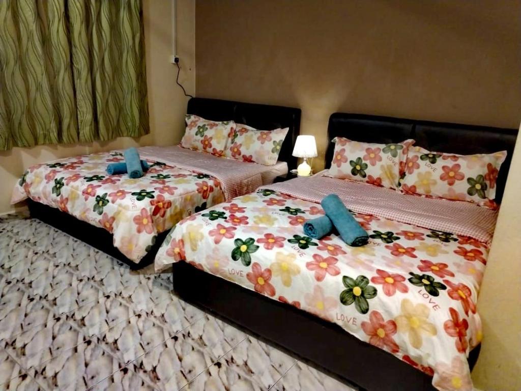 two beds sitting next to each other in a bedroom at 4F Motel and Homestay by LTS in Pantai Cenang