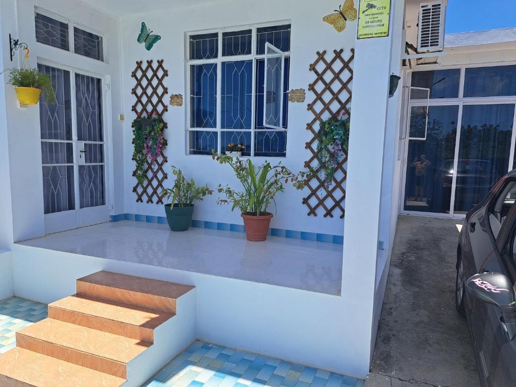 a house with a porch with stairs and plants at Belle maison in Goodlands