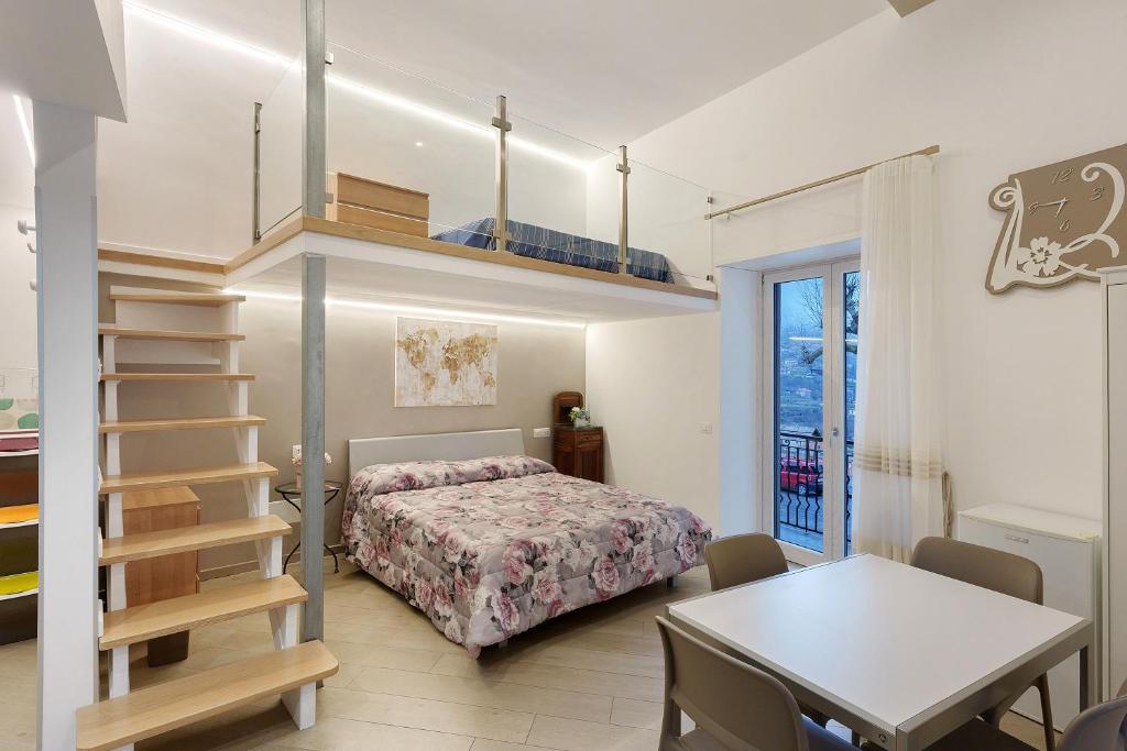 a bedroom with a bed and a staircase and a table at Casa Imperati in Agerola