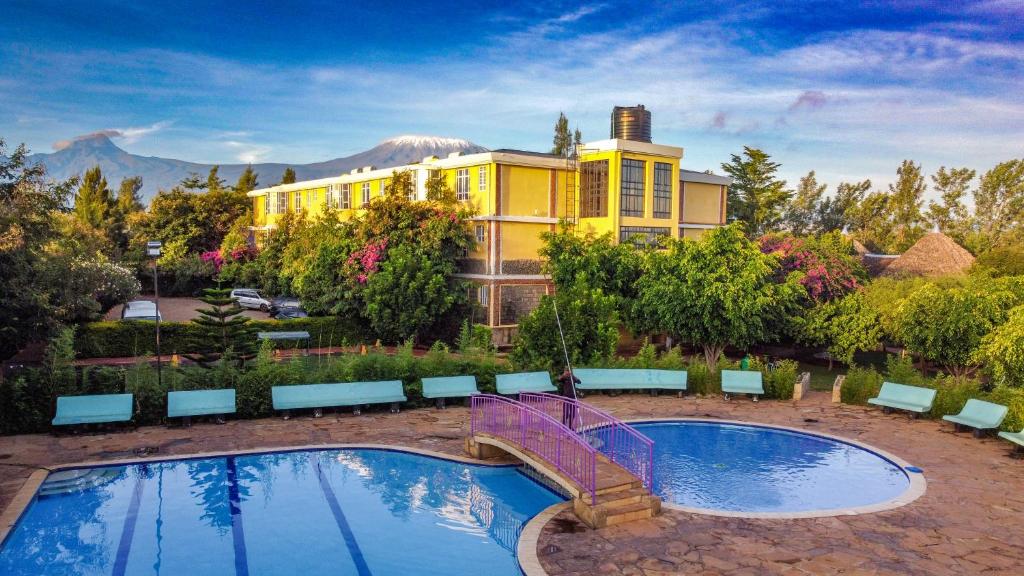a house with a pool and a purple bridge at Amboseli Gateway Hotel in Kimana