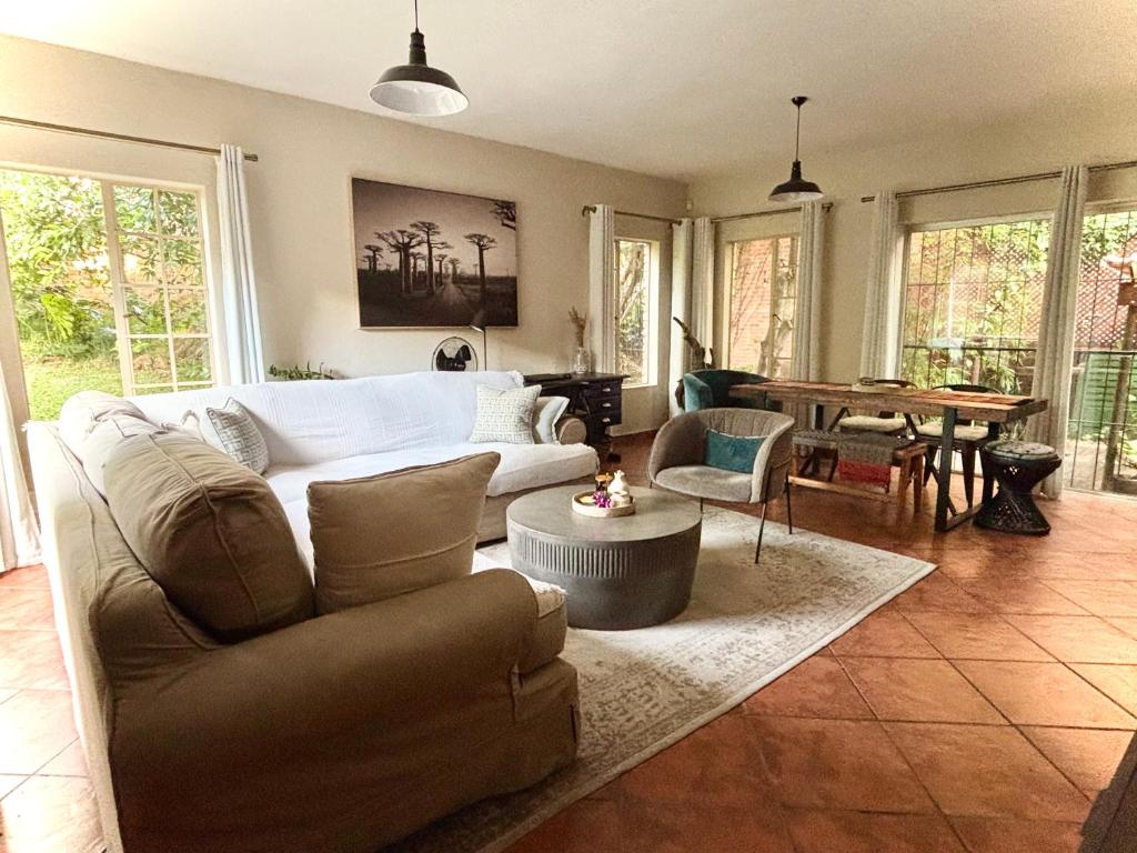 a living room with a couch and a table at Fig Tree Rock 2-bed, 2-bath villa with garden and parking in Nelspruit