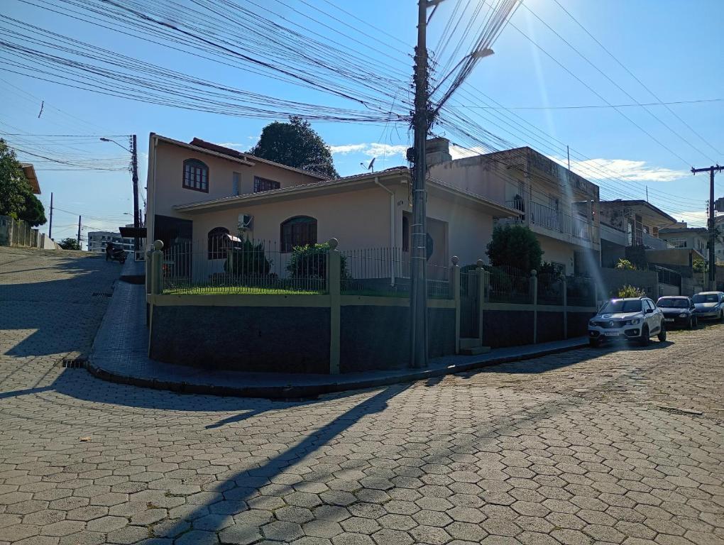 a house with a fence in front of a street at Casa 4 Quartos garagem 3 carros, churrasqueira e ar condicionado, in São José