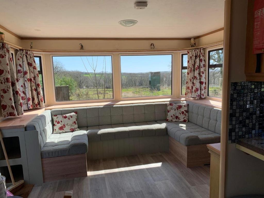 a living room with a couch in front of a window at tranquil holiday home Devon Cornwall border Bude in Pyworthy