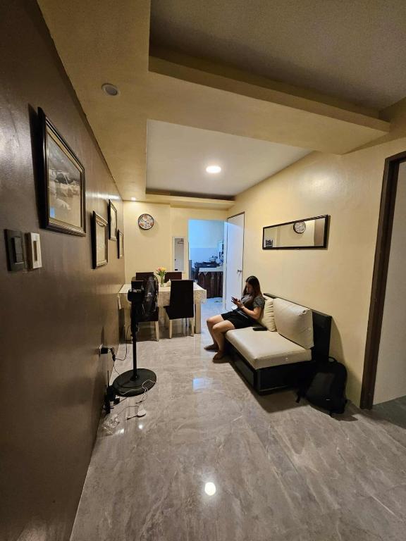 a woman sitting on a couch in a living room at Tony nature place in Antipolo