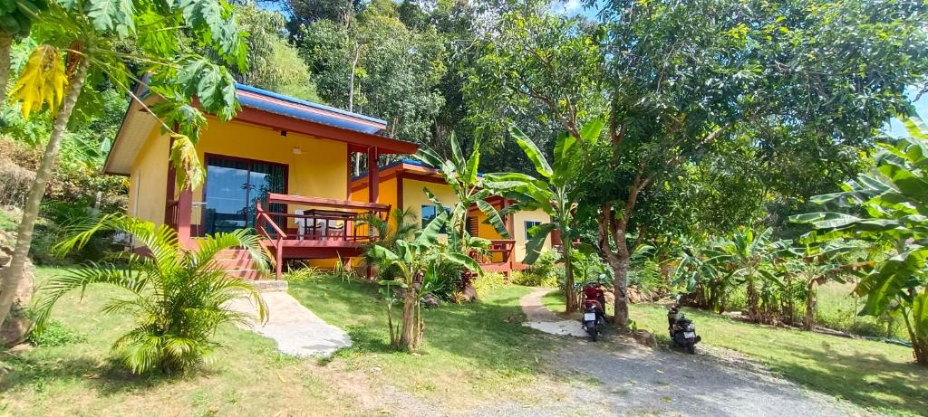 a yellow house in the middle of a forest at Alisa Bungalows in Ko Chang