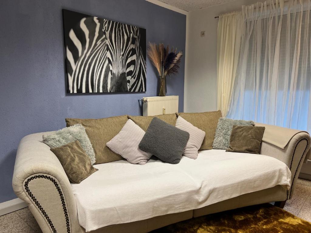 a living room with a white couch with pillows at Pension EdHeLo in Barby