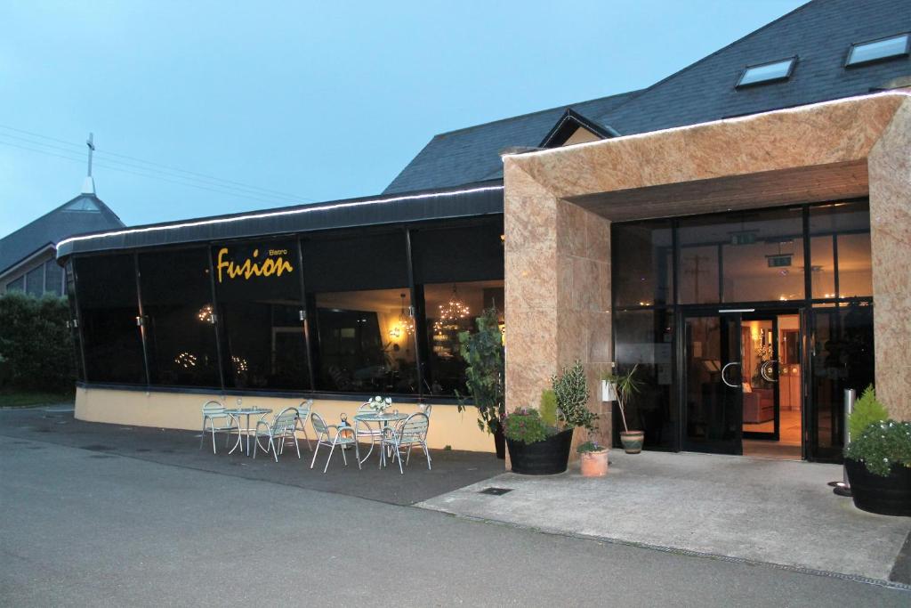 un restaurant avec des tables et des chaises à l'extérieur d'un bâtiment dans l'établissement Ferryport House B&B, à Rosslare