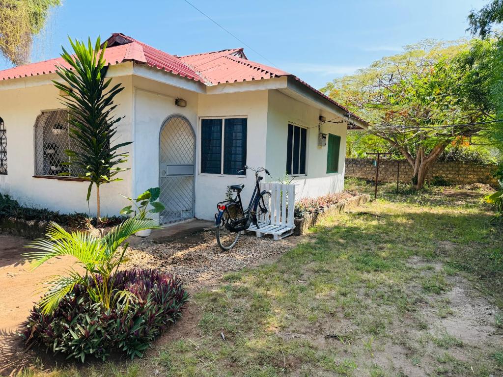 a bike parked in front of a house at Savita House Diani in Magutu