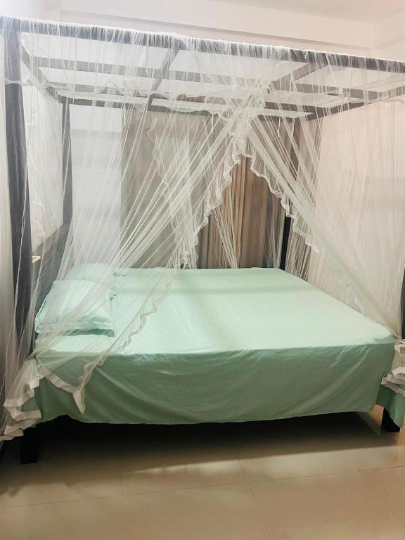 a bed covered in mosquito nets in a room at Senuka Villa in Mirissa