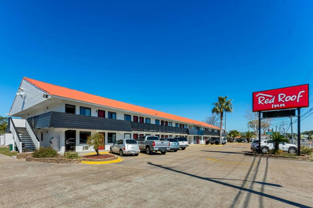 a red roof motel with cars parked in a parking lot at Red Roof Inn Panama City Beach in Panama City Beach