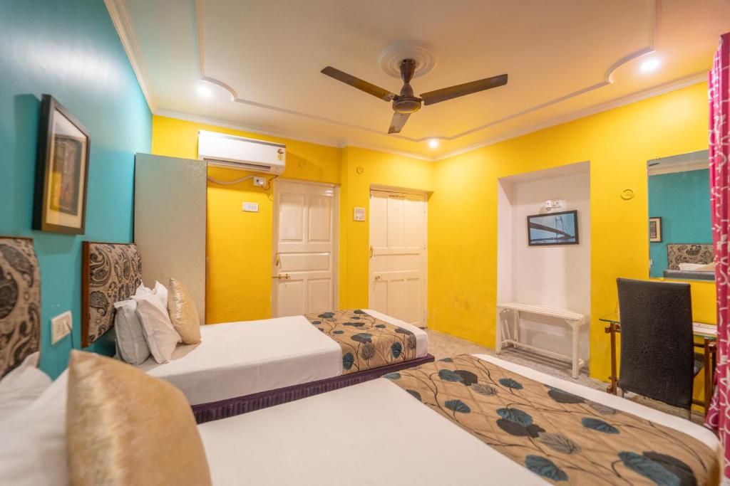 a bedroom with two beds and a tv in it at Tara Inn in Varanasi